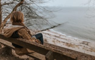 seasonal depression - woman sitting on bench in cold